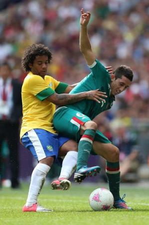 Marcelo, de Brasil, pelea por la bola con Hector Herrera, de México, en los últimos minutos del juego.