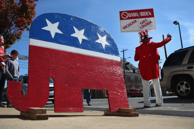 Un hombre muestra su postura anti-Obama y su apoyo a la campaña de Romney y su candidato a la vicepresidencia, Paul Ryan.