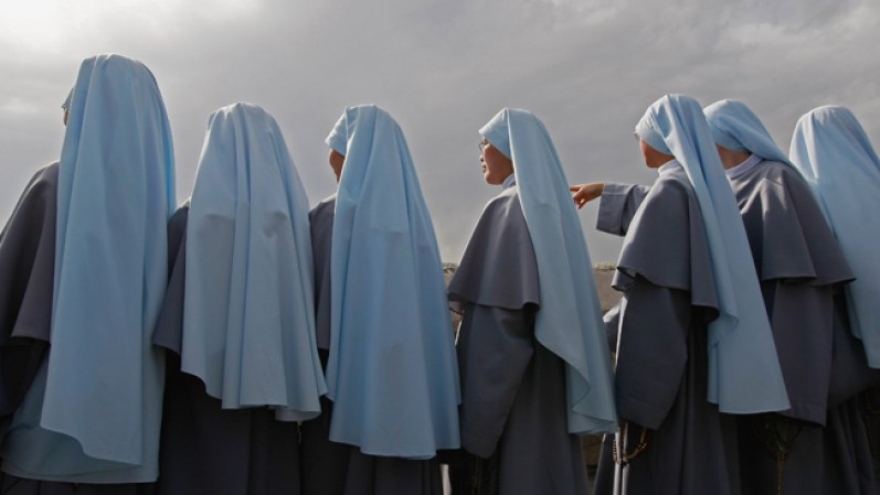 JERUSALEM - APRIL 05: Catholic nuns taking part in the traditional Palm Sunday procession from the Mt. of Olives pause to look down at the Old City on April 5, 2009 in Jerusalem, Israel. The festival, which falls at the start of the Holy Week, commemorates the triumphant entry of Jesus into Jerusalem in the days before his Passion, according to the Gospels of Mark, Matthew, Luke and John. (Photo by David Silverman/Getty Images)