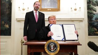 El presidente de los Estados Unidos, Donald Trump, sostiene un proyecto de ley de financiación de emergencia de $8,000 millones para combatir el coronavirus COVID-19, luego de firmarlo mientras el Secretario de Salud de los Estados Unidos, Alex Azar, observa en la Sala Diplomática de la Casa Blanca en Washington, DC el 6 de marzo de 2020.