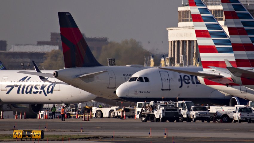 A JetBlue Airways plane taxis next to American Airlines, Delta Air Lines and Alaska Airlines aircraft at Reagan National Airport (DCA) in Arlington, Virginia, on Monday, April 6, 2020.