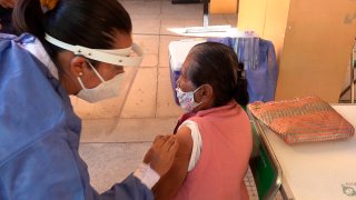 Una enfermera aplica una vacuna a mujer en Oaxaca
