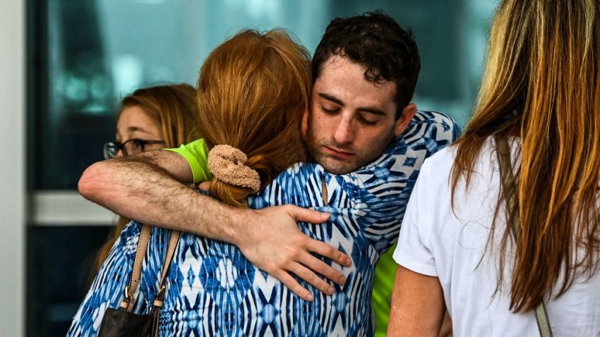 Family members and residents of the Champlain Towers South greet each other outside the Town of Surfside Community Center in Surfside, north of Miami Beach, on June 24, 2021. – The 12-story oceanfront apartment block in Florida partially collapsed early on June 24, killing at least one person and sparking a major emergency response with dozens of rescuers combing the rubble for survivors. (Photo by CHANDAN KHANNA / AFP) (Photo by CHANDAN KHANNA/AFP via Getty Images)