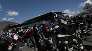 estudiantes chocan con policías frente a un autobús