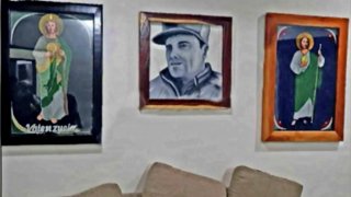 Fotografía de la pared de una celda con imágenes de santos y el chapo