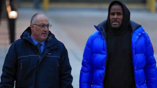 Fotografía de archivo, tomada en febrero de 2019, en la que se registró al cantante R. Kelly (d), al ser escoltado por su entonces abogado, Steve Greenberg, en Chicago.