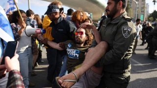 La policía israelí detiene a un manifestante frente al parlamento de Israel en Jerusalén en medio de manifestaciones en curso contra el controvertido impulso del gobierno de extrema derecha para reformar el sistema de justicia, el 27 de marzo de 2023.