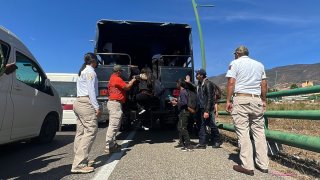 Foto de migrantes descendiendo de un tráiler.