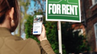 Woman looking for property to rent via real estate online platform on smartphone