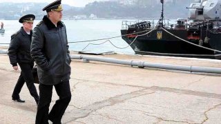 El comandante en jefe de la flota rusa del Mar Negro, Alexander Vitko (segundo a la izquierda), camina frente a barcos de la marina ucraniana amarrados en el puerto de Sebastopol el 20 de marzo de 2014.