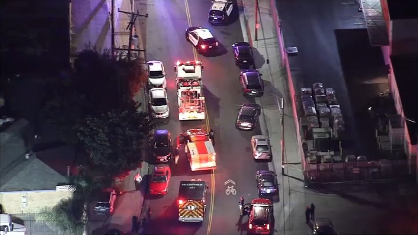 Fire trucks and police vehicles in the middle of a street in South Gate following a shooting.