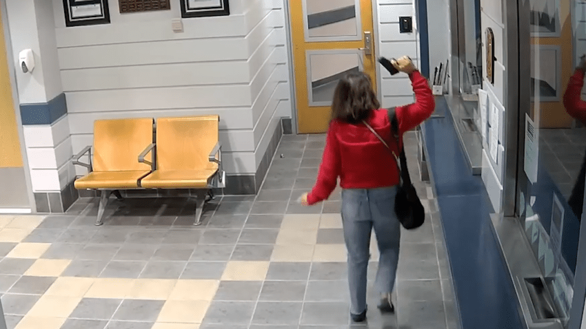 Woman in lobby of police station holding gun