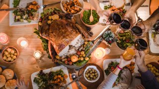 Overhead view of a Thanksgiving meal with turkey, red wine and orange juice.