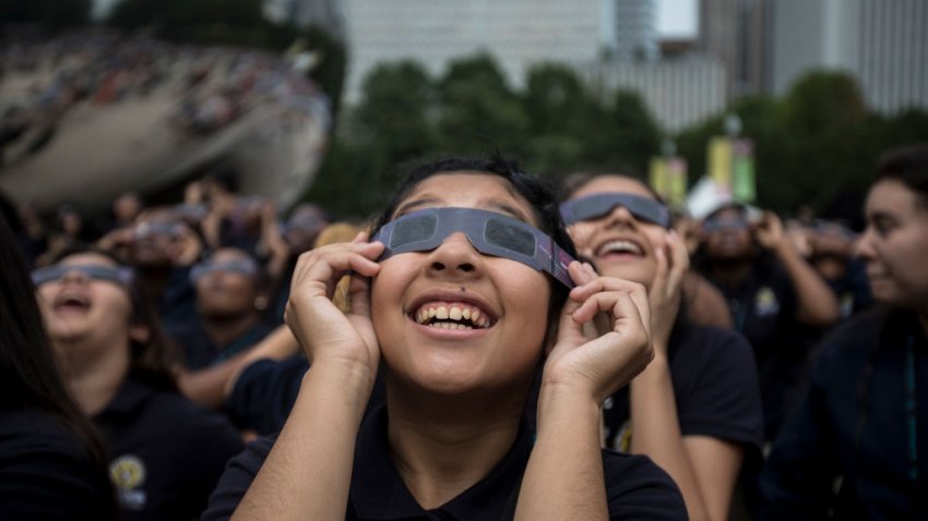 Students from Muchin College Prep react as the solar eclipse emerges from behind clouds in Millennium Park in Chicago on Aug. 21, 2017. (Alexandra Wimley/Chicago Tribune/Tribune News Service via Getty Images)