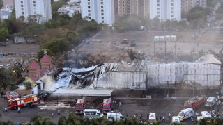 Bomberos combaten un incendio que estalló en un parque de diversiones de Rajkot en el estado de Gujarat, India, el sábado 25 de mayo.