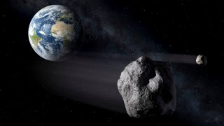 En esta recreación artística, dos asteroides pasan junto a la Tierra.