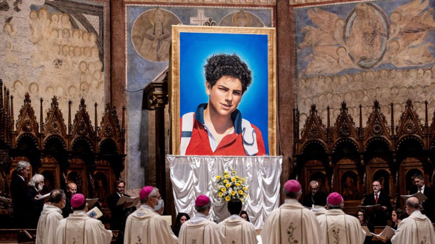 ASSISI, ITALY – OCTOBER 10: A tapestry featuring a portrait of Carlo Acutis is hang at the St. Francis Basilica during the beatification ceremony of Carlo Acutis, on October 10, 2020 in Assisi, Italy. The fifteen-year-old Carlo Acutis member of the Millennial generation who died on 12 October 2006 from M3 fulminant leukemia, is considered a “computer geek” on account of his passion and skill with computers and the internet. Acutis applied himself to creating a website dedicated to cataloguing each reported Eucharistic miracle in the world. (Photo by Vatican Pool/Getty Images)