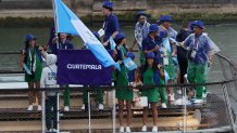 PARIS, FRANCE - JULY 26: Kevin Cordon and Ana Waleska Soto Abril, Flagbearers of Team Guatemala, are seen on a boat waving their flag along the River Seine during the opening ceremony of the Olympic Games Paris 2024 on July 26, 2024 in Paris, France. (Photo by Arturo Holmes/Getty Images)