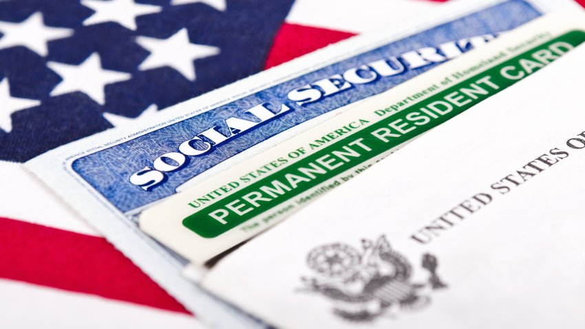 United States of America social security and green card with US flag on the background. Immigration concept. Closeup with shallow depth of field.