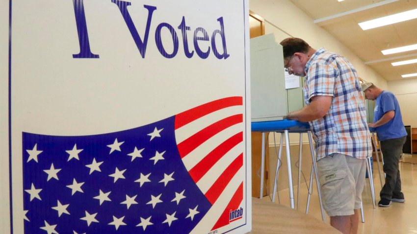 The side of a voting booth reads â€œI Votedâ€ as voters man other booths at the First Congregational Poll during the primary election, Tuesday, August 13, 2024, in Sheboygan Wis.