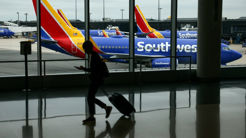 BALTIMORE, MARYLAND – 11 DE OCTUBRE: Un viajero pasa junto a un avión de Southwest Airlines mientras rueda desde una puerta en el Aeropuerto Internacional Thurgood Marshall de Baltimore Washington el 11 de octubre de 2021 en Baltimore, Maryland. Southwest Airlines está trabajando para ponerse al día con un atraso después de cancelar cientos de vuelos durante el fin de semana, culpando a problemas de control de tráfico aéreo y al clima. (Foto de Kevin Dietsch/Getty Images)