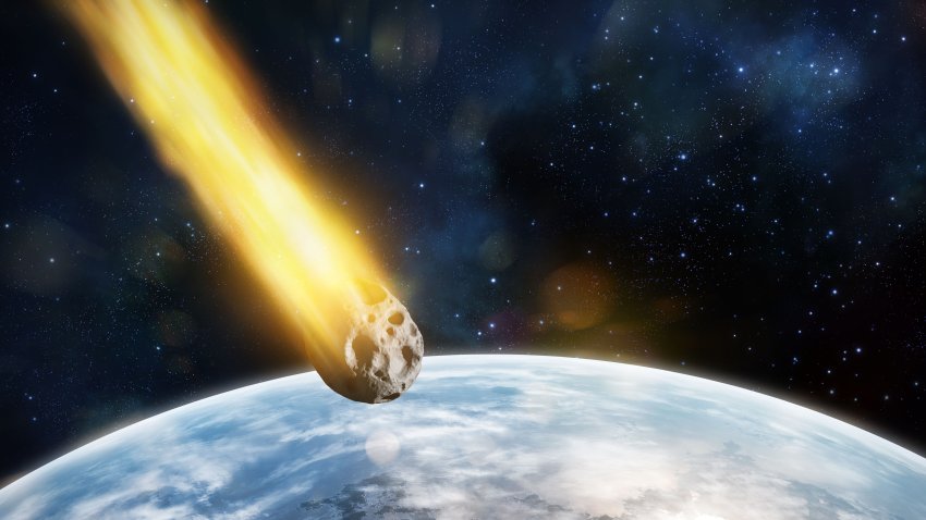 Digital illustration of asteroid entering atmosphere of a blue planet.